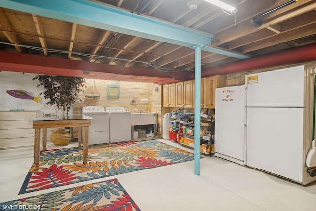 unfinished basement featuring independent washer and dryer and freestanding refrigerator