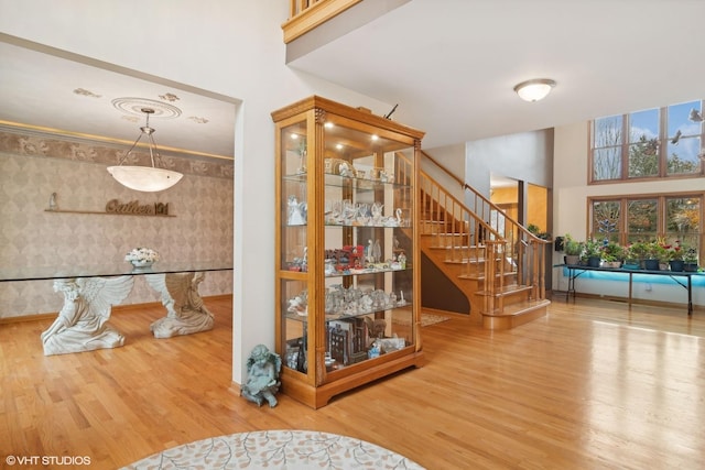 hallway featuring stairs, a high ceiling, and wood finished floors