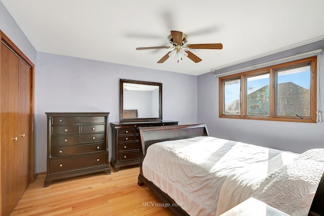 bedroom with a closet, light wood-type flooring, and a ceiling fan