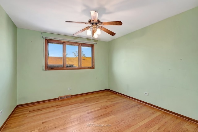 unfurnished room with visible vents, light wood-style flooring, baseboards, and a ceiling fan