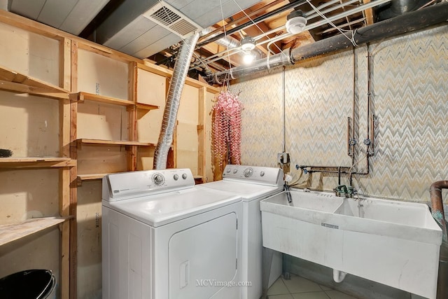 laundry room with visible vents, laundry area, tile patterned floors, washer and dryer, and a sink