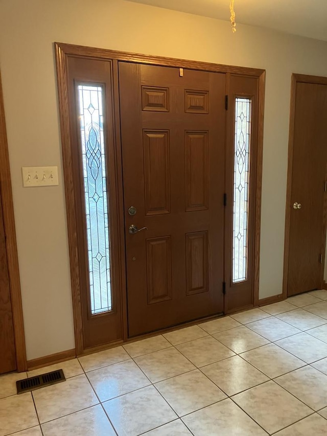 entryway with light tile patterned floors, visible vents, and baseboards