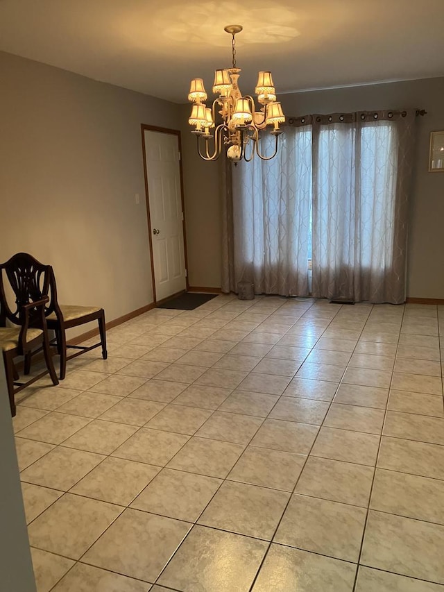 empty room with light tile patterned floors, baseboards, and an inviting chandelier