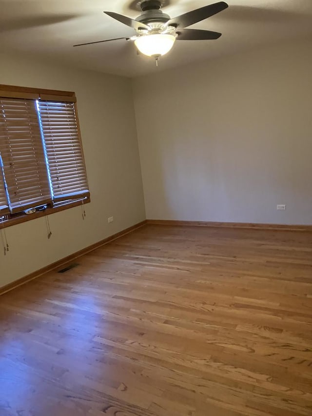 unfurnished room with light wood-type flooring, visible vents, baseboards, and ceiling fan