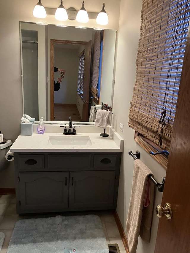 bathroom featuring tile patterned flooring, vanity, and baseboards