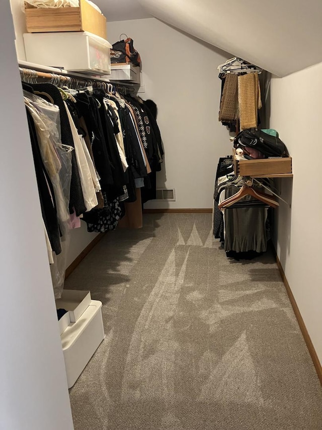 walk in closet featuring lofted ceiling, carpet, and visible vents