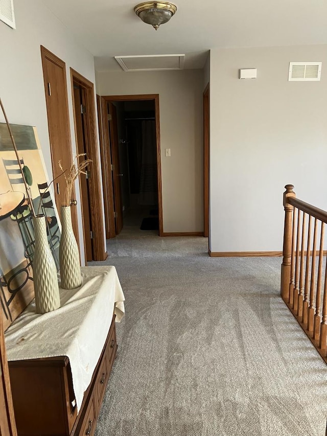 corridor with carpet, an upstairs landing, baseboards, and visible vents