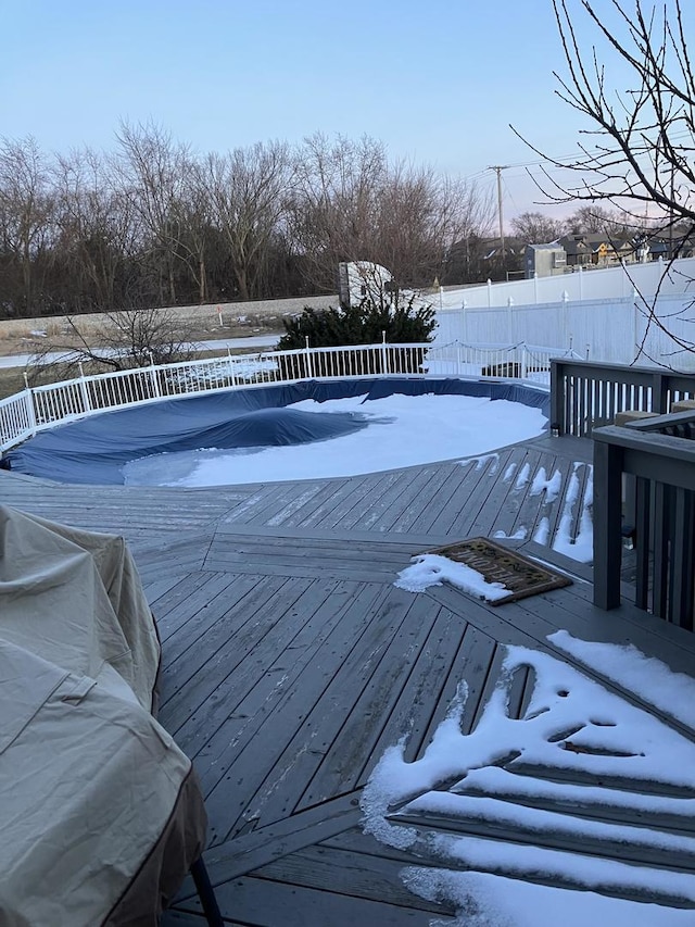 view of swimming pool featuring a deck and fence