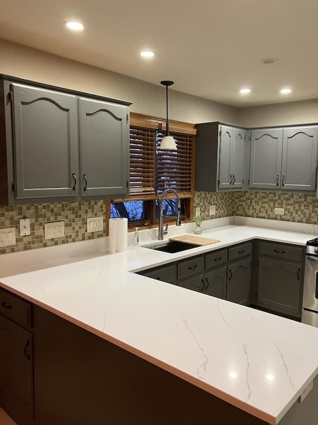 kitchen featuring pendant lighting, backsplash, and a sink