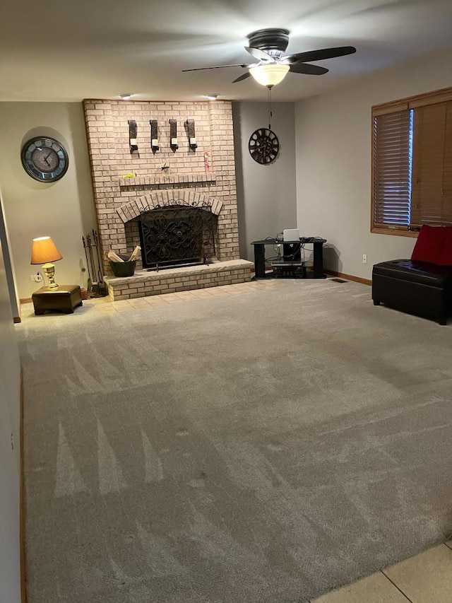 carpeted living area featuring a fireplace, baseboards, and a ceiling fan