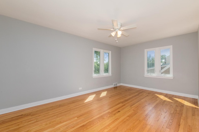 unfurnished room with visible vents, light wood-style flooring, baseboards, and ceiling fan