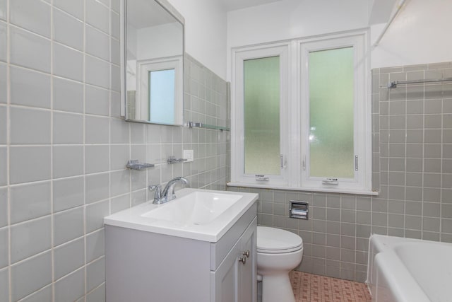 full bathroom with a tub, tile walls, vanity, and toilet