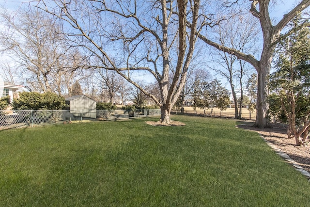 view of yard featuring a storage unit, an outbuilding, and a fenced backyard