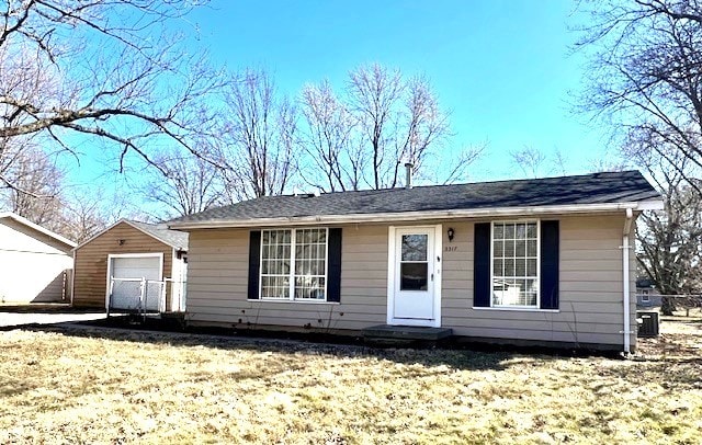 view of front of house featuring a garage and an outbuilding