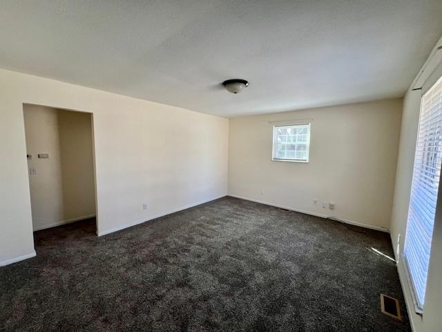 interior space with visible vents and dark colored carpet