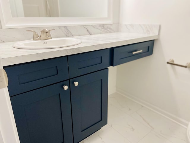 bathroom featuring baseboards, marble finish floor, and vanity