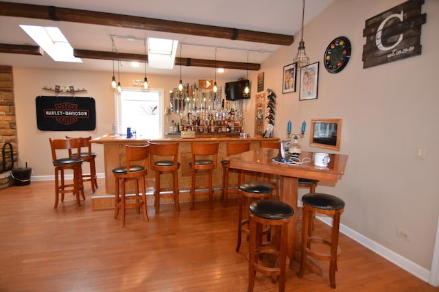 bar featuring beam ceiling, wet bar, baseboards, and wood finished floors