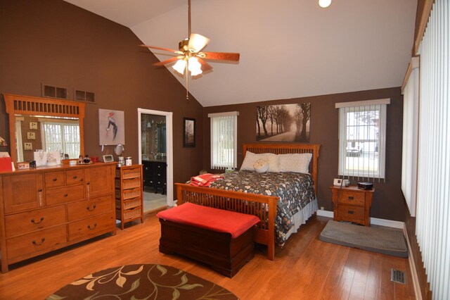 bedroom featuring visible vents, light wood-style floors, and high vaulted ceiling