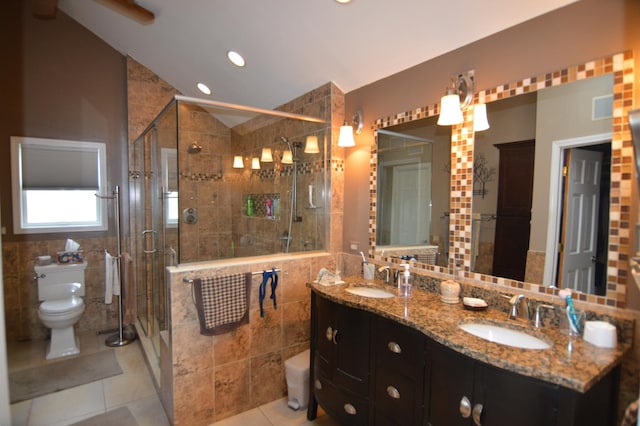 bathroom with a sink, lofted ceiling, toilet, and tile walls