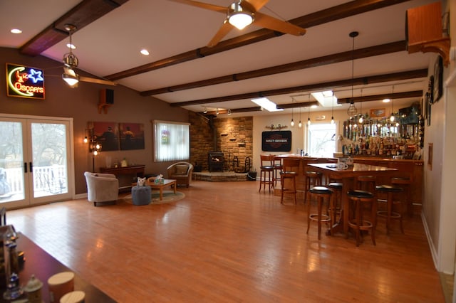 interior space with a community bar, french doors, lofted ceiling with beams, and wood finished floors