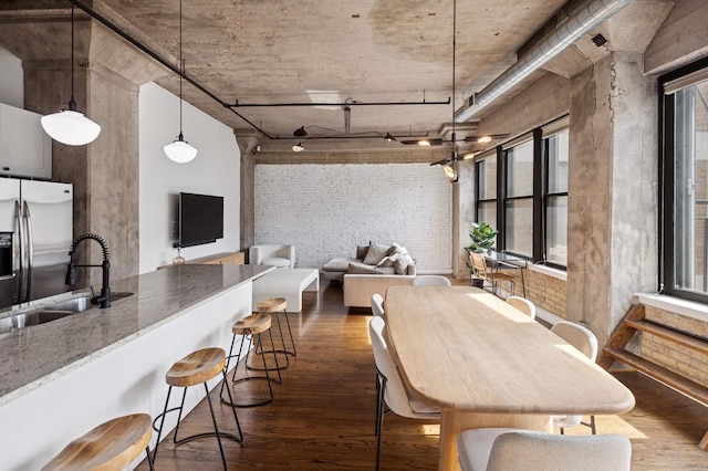 interior space with dark wood-style flooring and brick wall