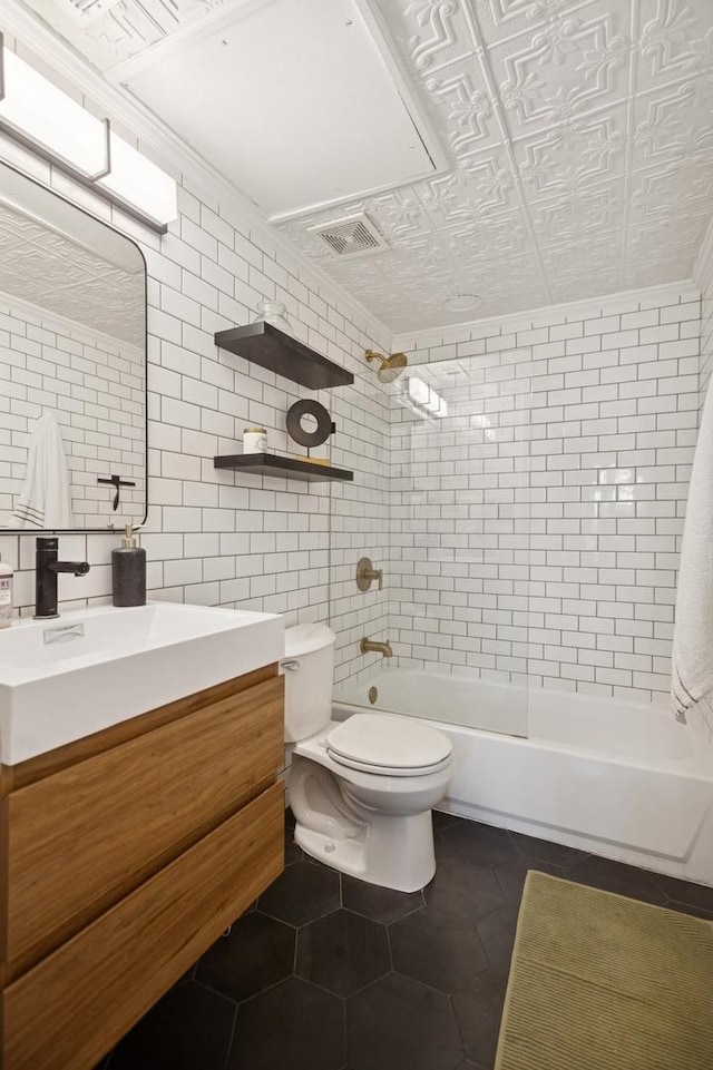 full bathroom with visible vents, decorative backsplash, tile patterned floors, toilet, and tile walls