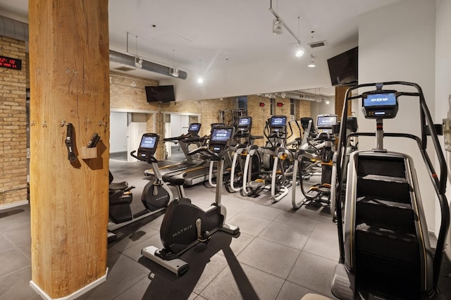 gym with visible vents, brick wall, and track lighting