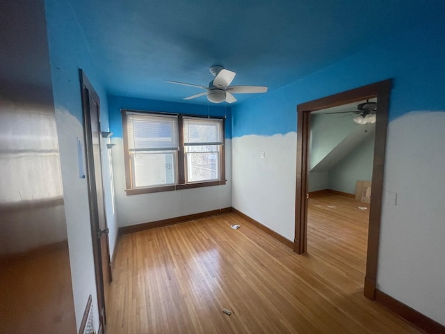 spare room featuring visible vents, wood finished floors, baseboards, and ceiling fan