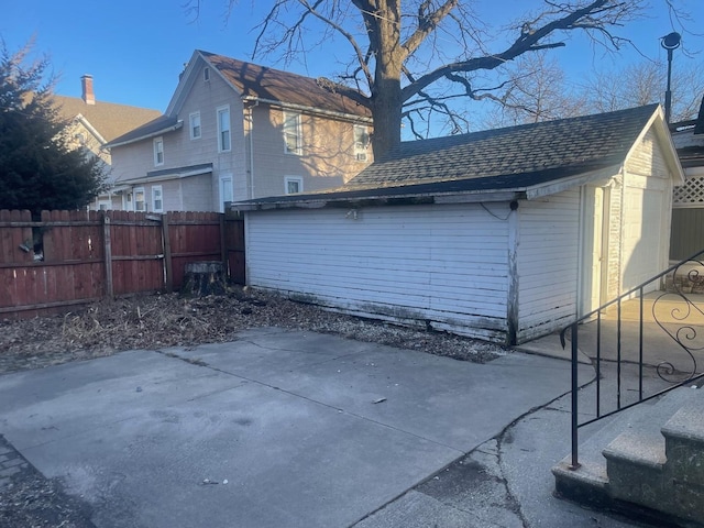 back of house with a patio area, fence, and a shingled roof