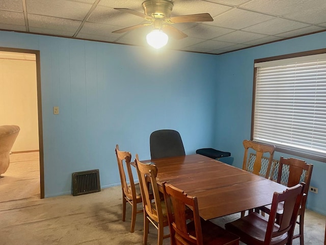 dining room with a ceiling fan, carpet, baseboards, and a paneled ceiling