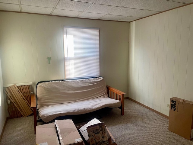 living area with a drop ceiling, baseboards, and carpet floors