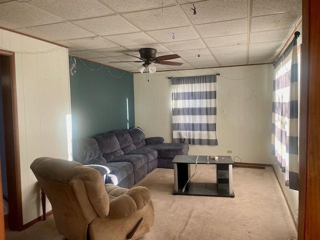 carpeted living area featuring a wealth of natural light, a paneled ceiling, and a ceiling fan