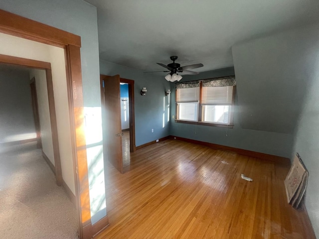 spare room with ceiling fan, baseboards, and light wood-style floors