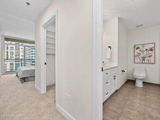 bathroom with vanity, toilet, visible vents, and baseboards