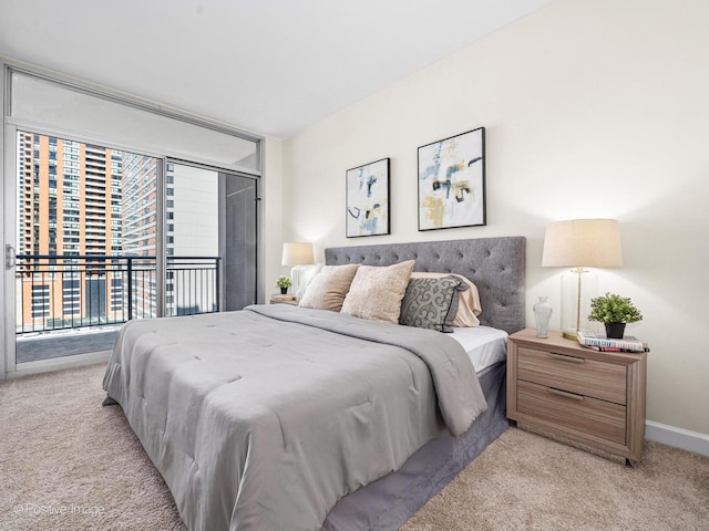 bedroom featuring a wall of windows, baseboards, light carpet, and access to outside