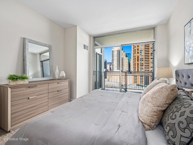 bedroom with visible vents, expansive windows, and access to outside