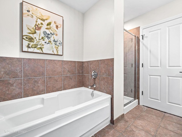 full bath featuring tile patterned flooring, a stall shower, and a bath