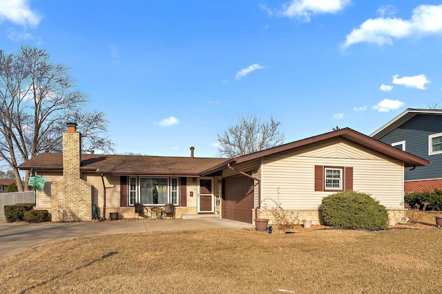 ranch-style home featuring a chimney, concrete driveway, a garage, and a front yard