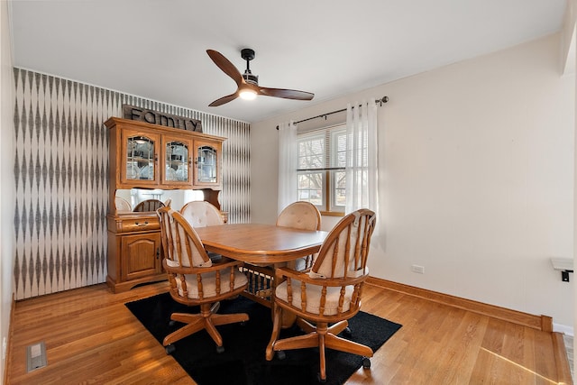 dining space with visible vents, light wood-style flooring, baseboards, and ceiling fan