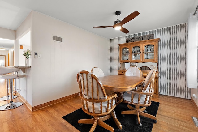 dining area featuring visible vents, baseboards, light wood-style floors, and a ceiling fan