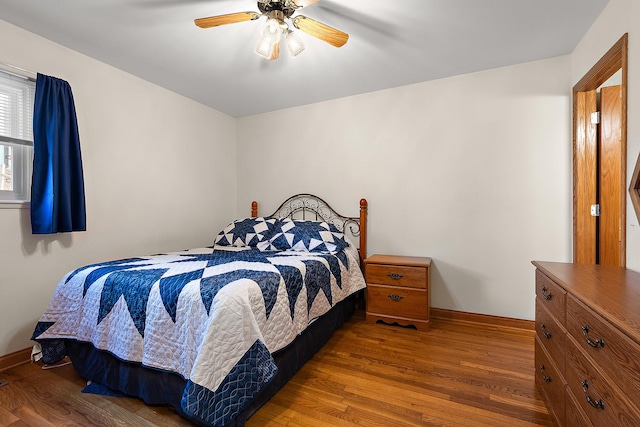 bedroom with ceiling fan, baseboards, and wood finished floors