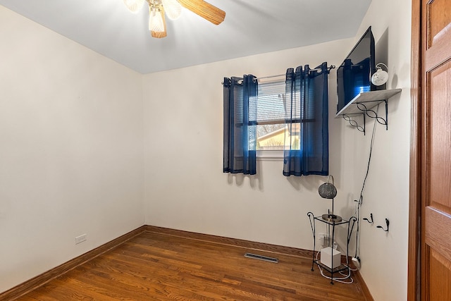 unfurnished room featuring visible vents, ceiling fan, baseboards, and wood finished floors