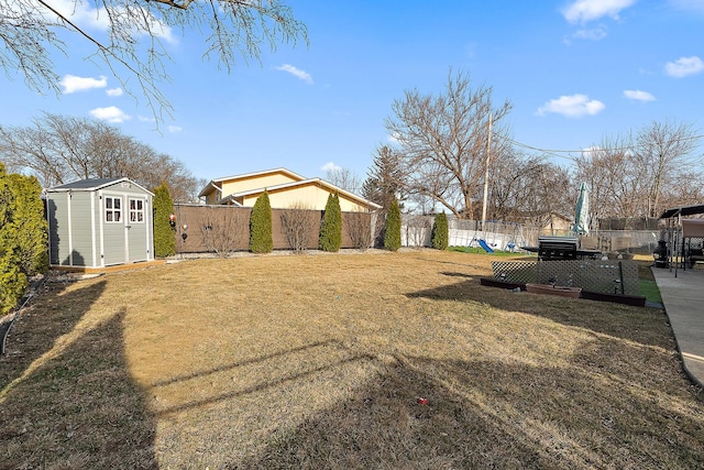 view of yard featuring a storage unit, an outdoor structure, and fence