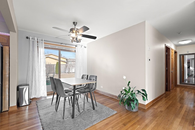 dining room featuring wood finished floors, baseboards, and ceiling fan