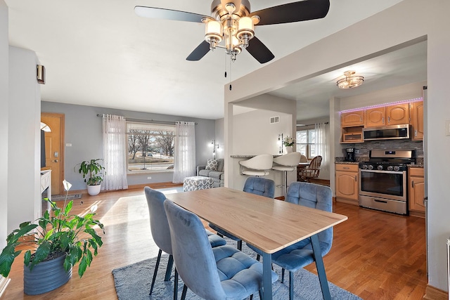 dining room featuring visible vents, baseboards, and light wood-style flooring