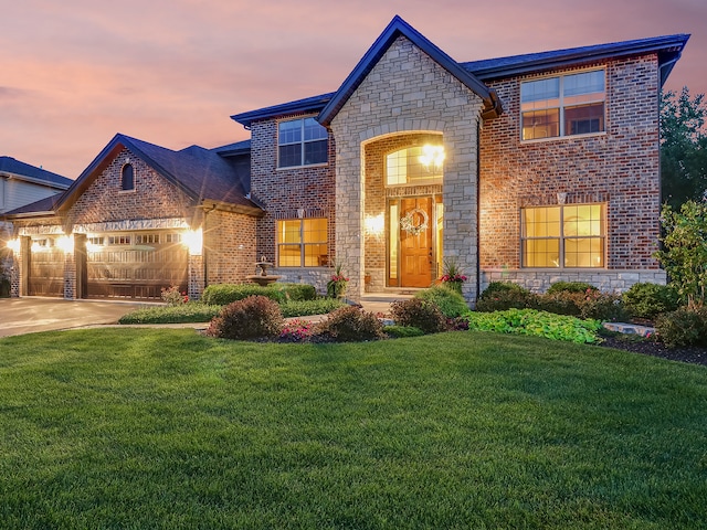 view of front of house with brick siding, driveway, a front lawn, and a garage