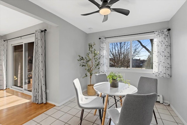 dining space featuring light tile patterned floors, a ceiling fan, and baseboards