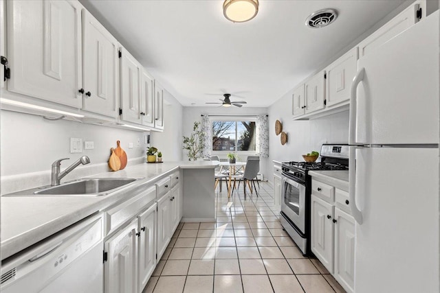 kitchen featuring white appliances, a ceiling fan, visible vents, a sink, and white cabinetry