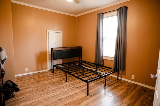 bedroom with ceiling fan, crown molding, baseboards, and wood finished floors