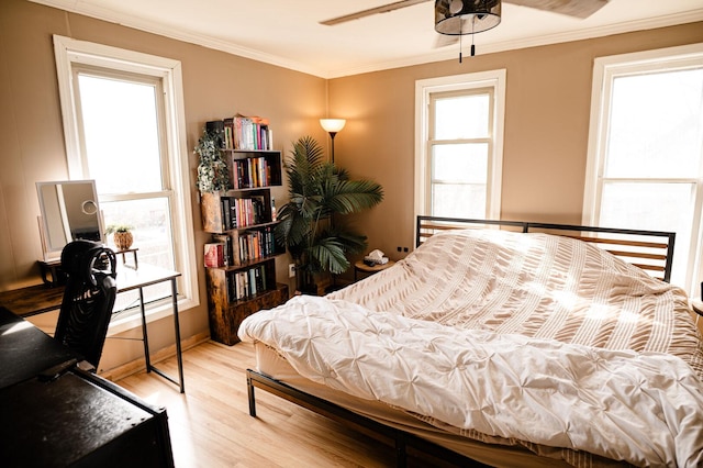 bedroom with wood finished floors and ornamental molding